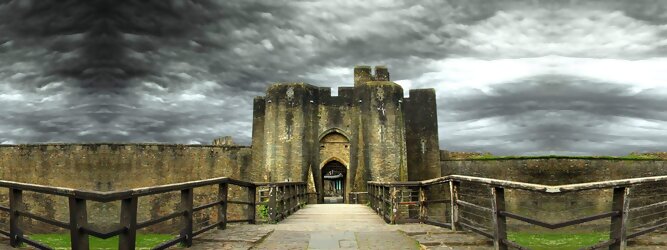 Trip Pauschal Reisetipps - Caerphilly Castle - ein Bollwerk aus dem 13. Jahrhundert in Wales, Vereinigtes Königreich. Mit einem aufsehenerregenden Turm, der schiefer ist wie der Schiefe Turm zu Pisa. Wie jede Burg mit Prestige, hat sie auch einen Geist, „The Green Lady“ spukt in den Gemächern, wo ihr Geliebter den Tod fand. Wo man in Wales oft – und nicht ohne Grund – das Gefühl hat, dass ein Schloss ziemlich gleich ist, ist Caerphilly Castle bei Cardiff eine sehr willkommene Abwechslung. Die Burg ist nicht nur deutlich größer, sondern auch älter als die Burgen, die später von Edward I. als Ring um Snowdonia gebaut wurden.